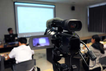 Photographer recording  video lecturer and student learning in classroom of university. - Education or seminar concept selective focus on video camera.