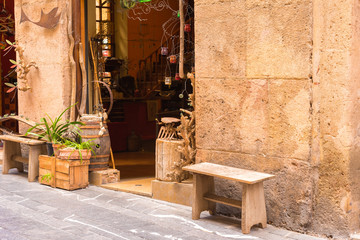 Wall Mural - TARRAGONA, SPAIN – MAY 1, 2017: Souvenir shop in the street of Europe. Bench close-up. Copy space.