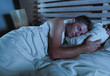 © TheVisualsYouNeed - young attractive and handsome tired man on his 30s or 40s in bed sleeping peacefully and relaxed at apartment bedroom resting comfortable at night