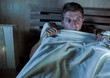 © TheVisualsYouNeed - sleepless young man lying in bed stressed and scared suffering nightmare and horror bad dream grabbing duvet frightened and paranoid in sleeping disorder