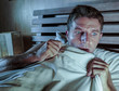 © TheVisualsYouNeed - sleepless young man lying in bed stressed and scared suffering nightmare and horror bad dream grabbing duvet frightened and paranoid in sleeping disorder