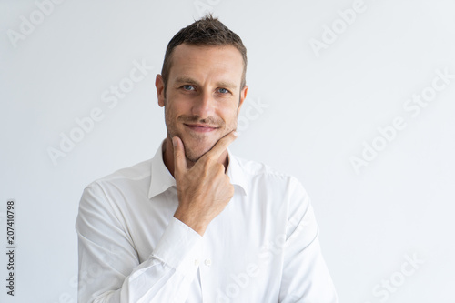 Fotomural Portrait of mid adult businessman with interested expression touching his chin