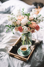 Delicious Fresh Morning Espresso Coffee In Bed With A Beautiful Blossoming Flower Bouquet Of Mattiolas, Peony, Carnations, Roses
