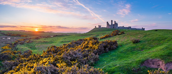 Wall Mural - dunstanburgh castle panorama at sunset / located between craster and embleton in northumberland on t