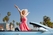 © Syda Productions - travel, summer holidays, road trip and people concept - happy young woman wearing hat in convertible car enjoying sun over venice beach background in california