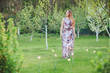 © Volodymyr Shcherbak - Young woman enjoying spring in the green field with blooming trees