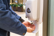 © ThamKC - Person cleaning hand with anti-bacterial diinfectant sanitizer in public mall