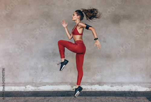 Cuadros en Lienzo Sportswoman jumping and stretching