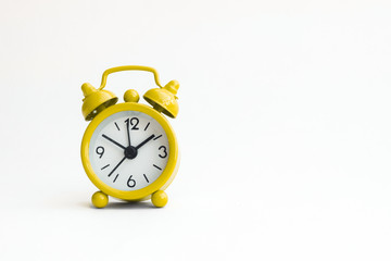 small analogue yellow golden clock in isolated white background