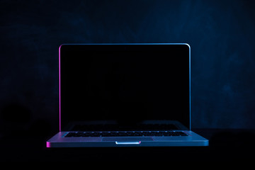 portable modern silver computer on a black background.