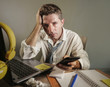 © TheVisualsYouNeed - attractive sad and desperate man in lose necktie looking messy and depressed working at laptop computer desk in business office problem and stress concept