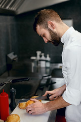 Wall Mural - Chef Cooking Burgers in Kitchen