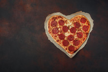 Heart Shaped Pizza With Mozzarella And Sausage. Valentines Day Greeting Card On Rusty Background