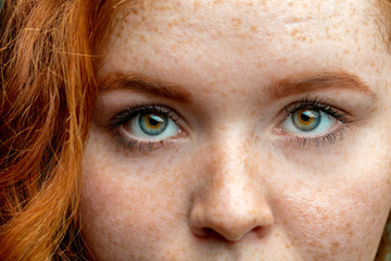 Wall Mural - Close up eyes of young red ginger freckled woman with perfect healthy freckled skin, looking at camera. Ophthalmology, Vision care