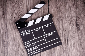 holding clapper board or slate film concept On wooden table.