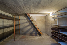 Empty Basement In Abandoned Old Industrial Building With Little Light And A Wooden Stairs