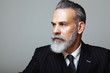 © SFIO CRACHO - Close-up portrait of bearded gentleman wearing trendy suit over empty gray background. Copy Paste space.