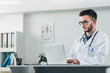 © Suteren Studio - Young doctor working on laptop