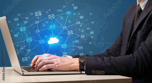Fotografía Businessman hand sending a bunch of messages on laptop with cloud computing conc