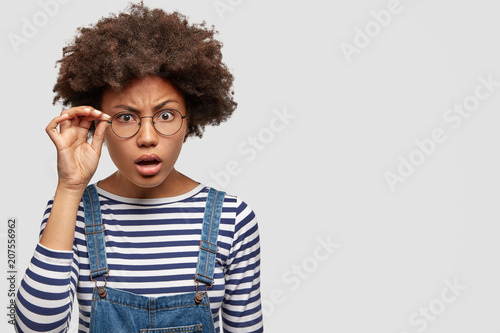 Fotografía Image of beautiful African American female looks scrupulously and attentively th