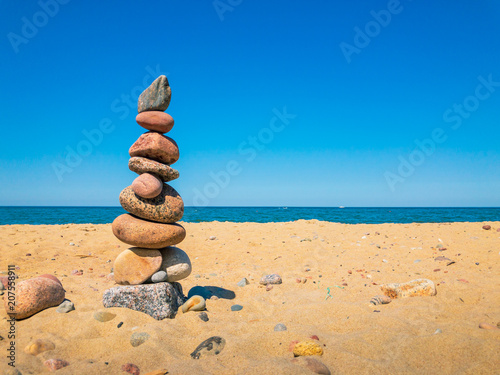 Cuadros en Lienzo Stones in the pyramid stand on the sandy sea beach