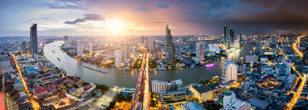Aerial view of Bangkok skyline and skyscraper with light trails on Sathorn Road center of business in Bangkok downtown. Panorama of Taksin Bridge over Chao Phraya River Bangkok Thailand at sunset. - obrazy, fototapety, plakaty 