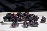 Fototapeta  - Bunch of fresh organic blackberries in a white plate.