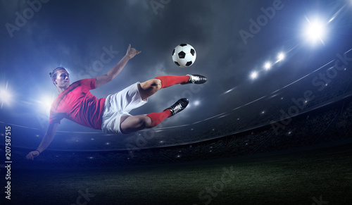 Fototapeta na szkło Gracz piłki nożnej w akci na stadium tle.