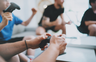 Friendship, technology, games and relaxing time at home concept - close up of male friends playing video games at living room.Closeup