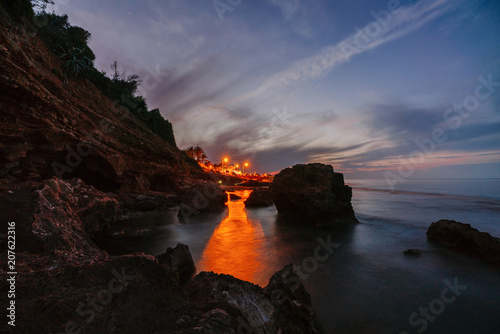 Fotografie, Obraz Sunset on the beach among the rocks near the city of Denia