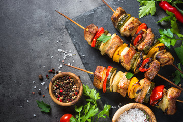 Grilled shish kebab with vegetables  on black.