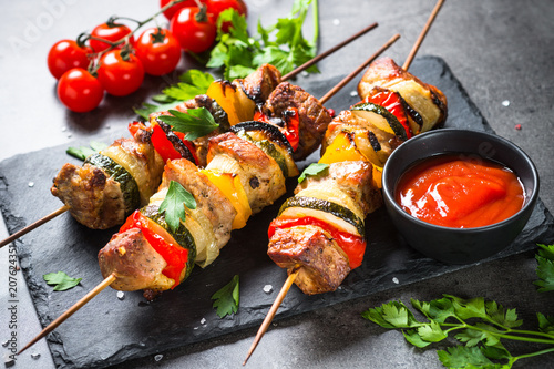 Fotografía Grilled shish kebab with vegetables on black.