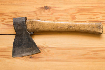 Old axe on wooden table . On wooden background