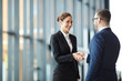 © pressmaster - Young smiling businesswoman giving handshake to foreign business partner at meeting