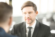 © pressmaster - Young serious businessman looking at his colleague during conversation at meeting