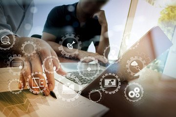 Poster - business documents on office table with smart phone and laptop and two colleagues discussing data in the background