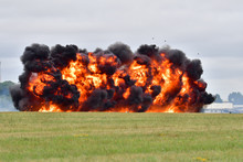 An Explosion At RAF Fairford During A Simulated Ground Attack. Orange Flames And Debris Can Be Seen Against Thick Black Smoke