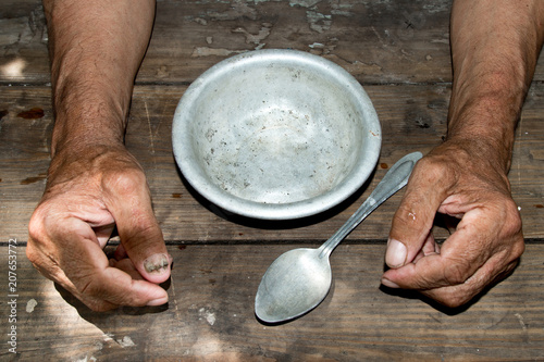 Fotomural hands the poor old man's and empty bowl on wood background