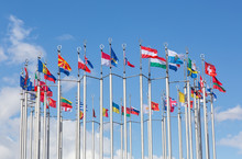 Flags Of European States On Flagpoles Against Background Of Cloudy Sky.