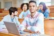 © Seventyfour - Portrait of college student sitting at the desk with laptop