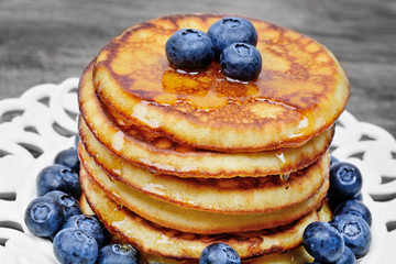 Canvas Print - Pancakes with honey and blueberries in a plate on a wood table