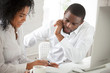 © fizkes - Two African American workers talking discussing business ideas, negotiating about corporate project, female black colleague explaining to male associate listening attentively. Cooperation concept