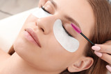 Fototapeta  - Young woman undergoing eyelash extensions procedure, closeup