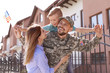 © New Africa - Male soldier reunited with his family outdoors. Military service