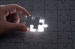 © showcake - Hand embed missing puzzle piece into place with light glow,success, teamwork and finishing or ending