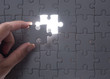 © showcake - Hand embed missing puzzle piece into place with light glow,success, teamwork and finishing or ending