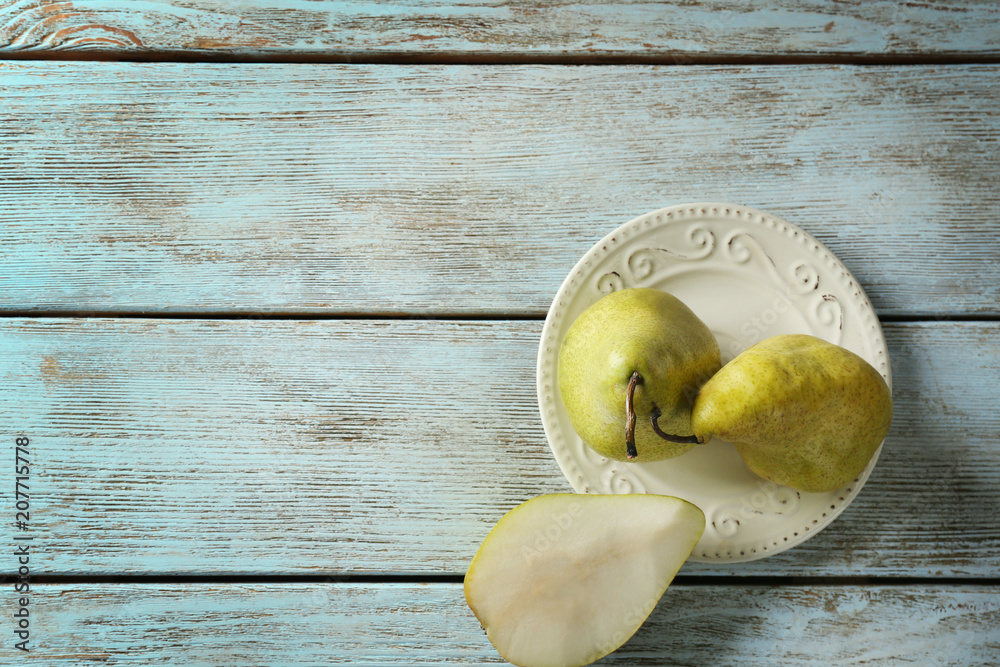 Plate with delicious pears on table