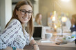 © goodluz - Cheerful trendy girl in co-working office