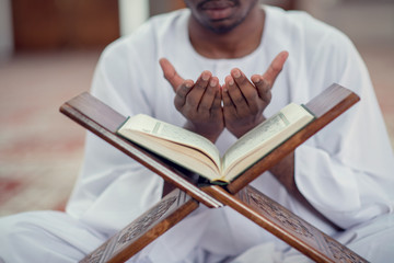 Wall Mural - Black African Muslim Man Is Praying In The Mosque with open holy book of Koran