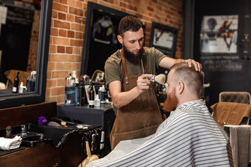 Barber and bearded man in barber shop